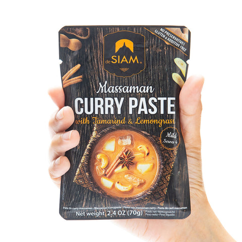 Hand holding a package of Siam Massaman Curry Paste with Tamarind & Lemongrass.